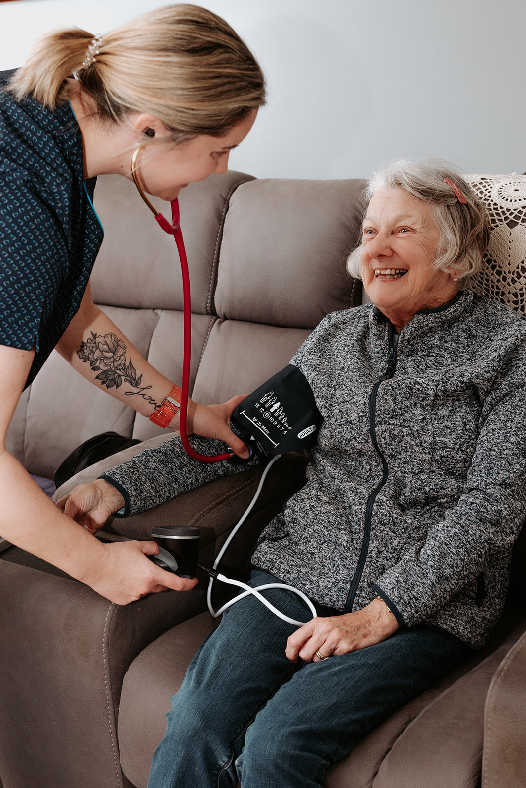 Nurse providing in-home aged care by checking elderly woman’s blood pressure in Portland, Victoria.